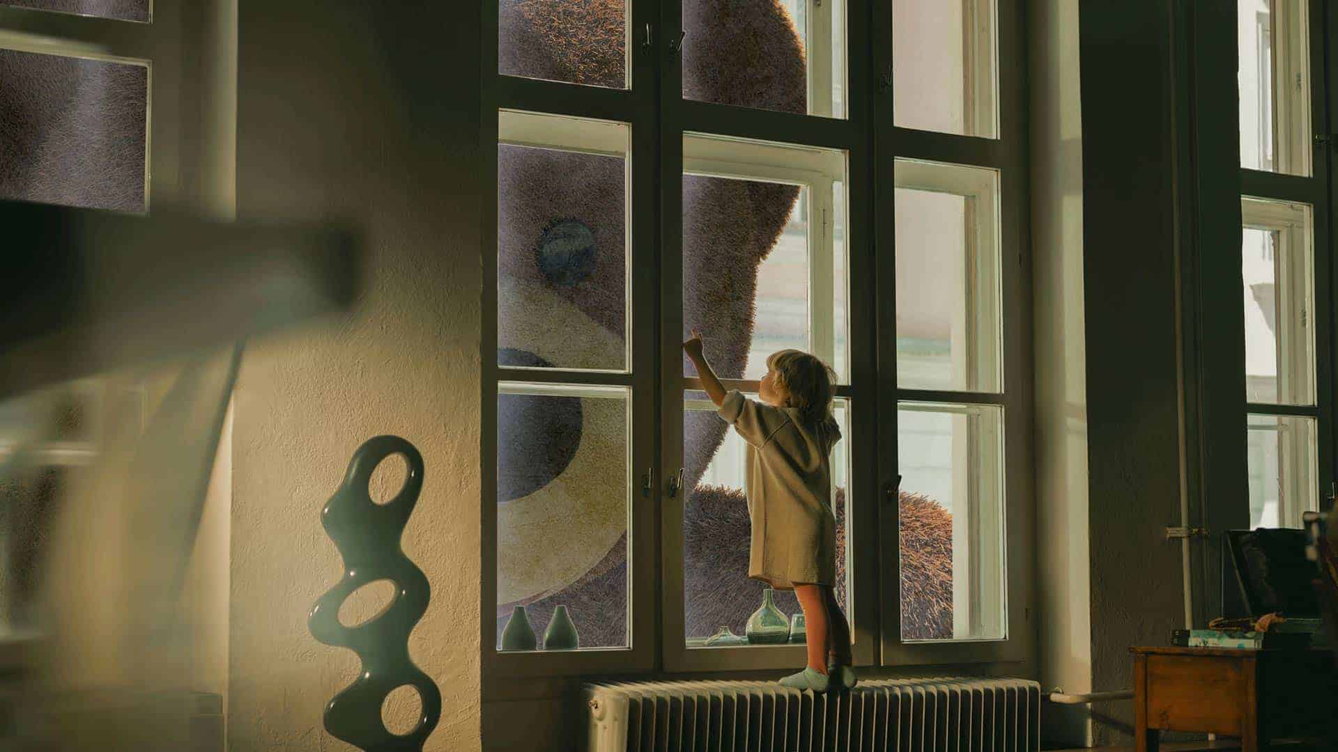 kid standing at a window